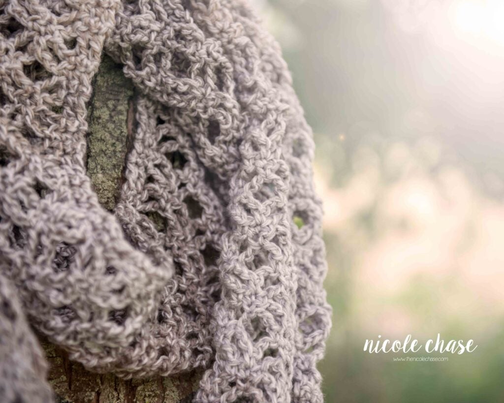 lacy scarf crochet pattern shown in a gray yarn with the sunshine in the background