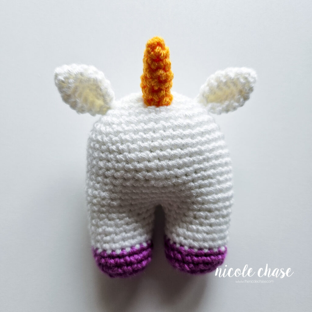A front view of the baby unicorn crochet pattern with the horn sewn into place.