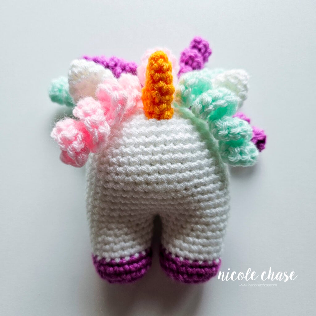 A view of the front of the baby unicorn with all of the hair curls sewn into place on the back of the head.