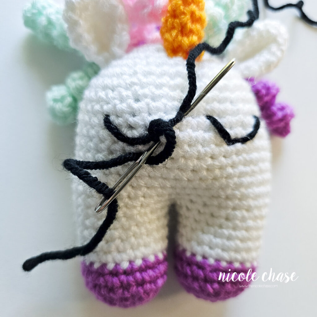 The yarn has looped around to further secure the dip in the embroidered sleepy eye.