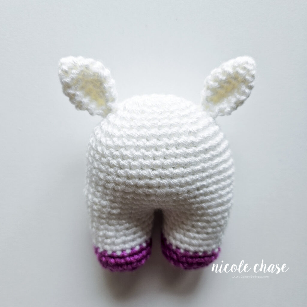 A view from the front of the unicorn baby toy showing the proper placement of the crochet ears.