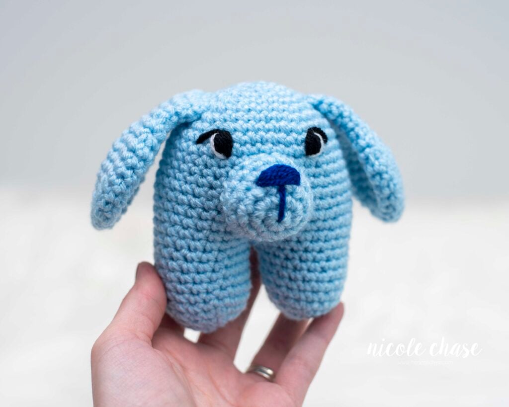 blue crochet puppy in a unique shape with embroidered details