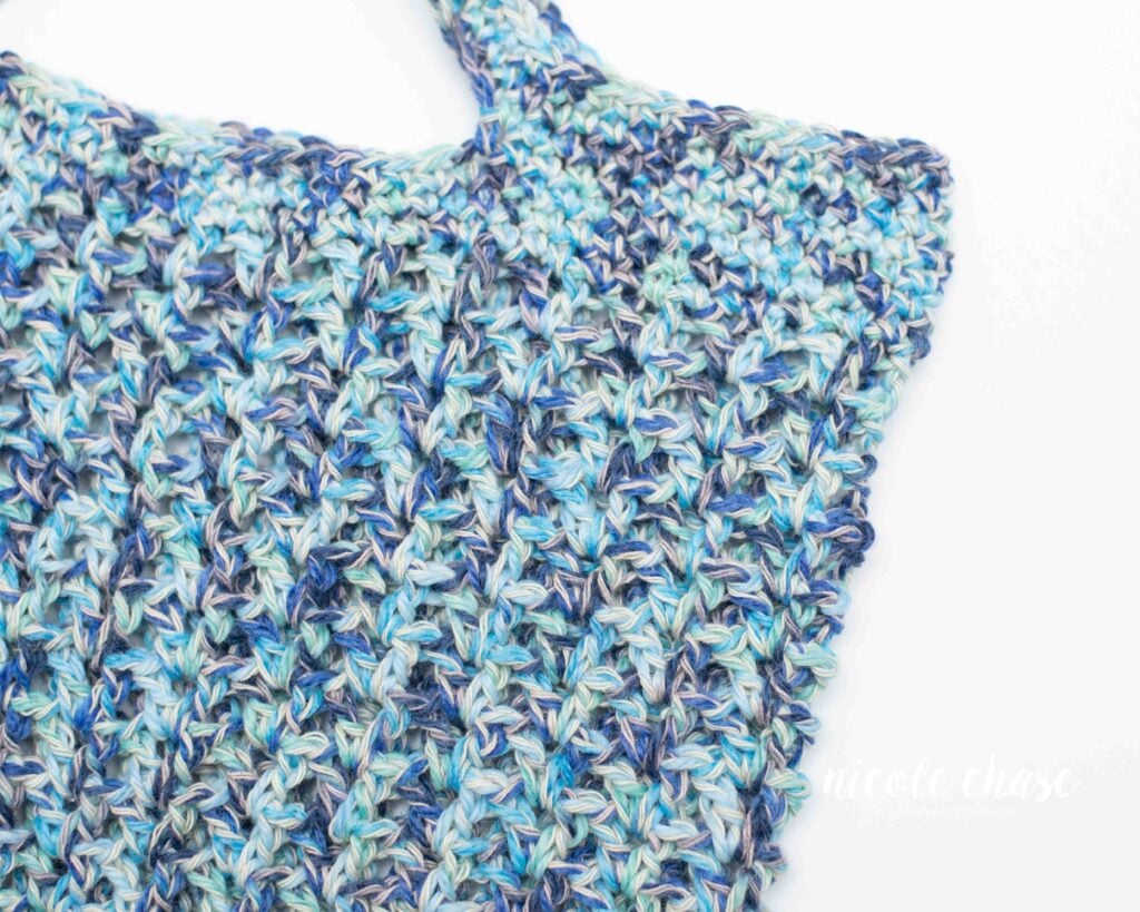Close-up detail of the V-stitch crochet mesh on the Chase Tote, highlighting the breathable texture of the bag made in blue cotton yarn. 