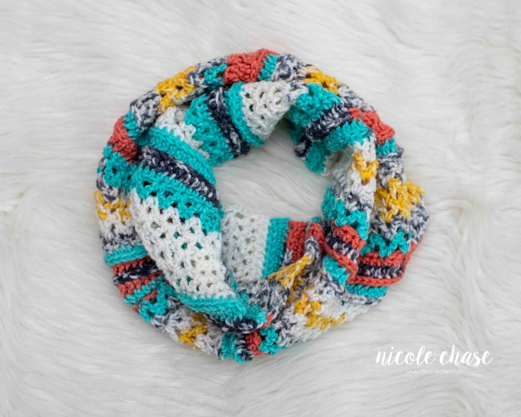 Top-down view of the multi-colored New Beginnings Cowl (an easy, free cowl crochet pattern), showcasing the textured stitches and bright yarn colors.