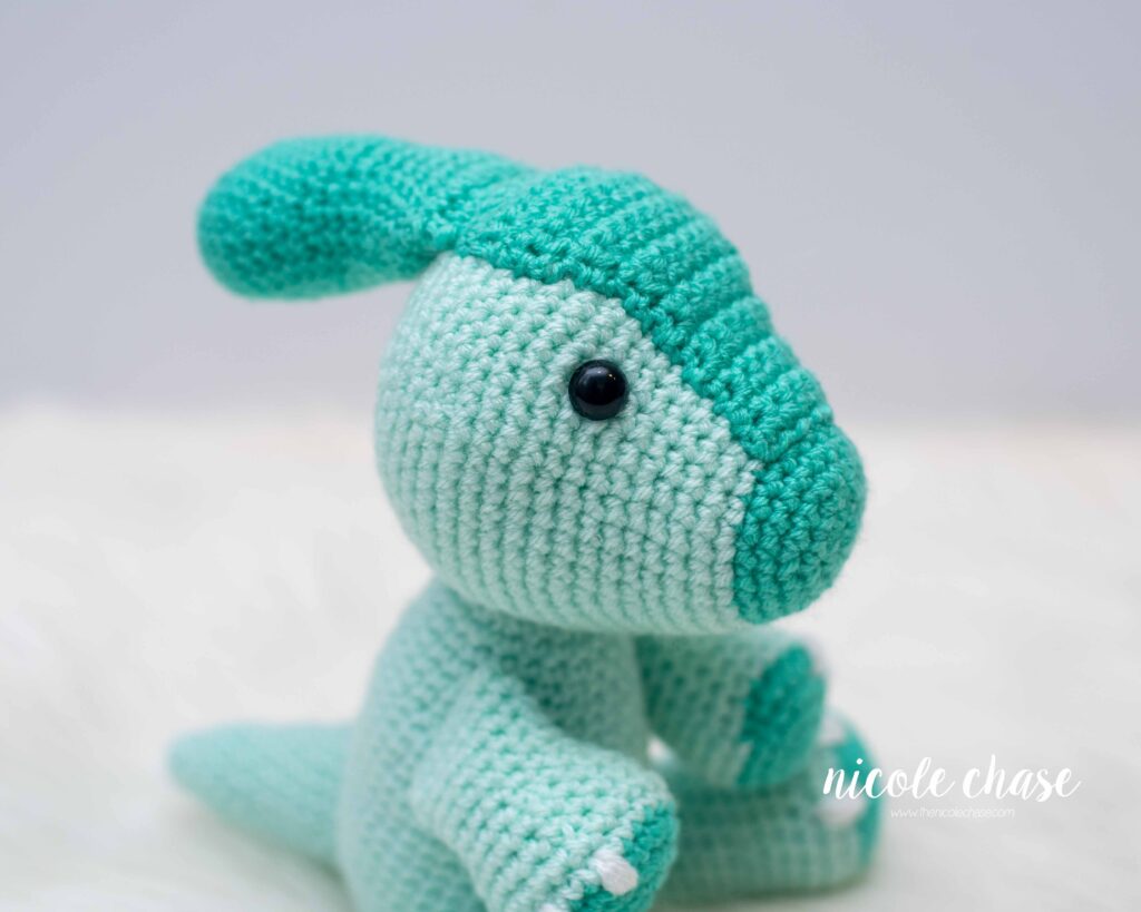 side view of amigurumi parasaurolophus crochet pattern in mint and teal colors