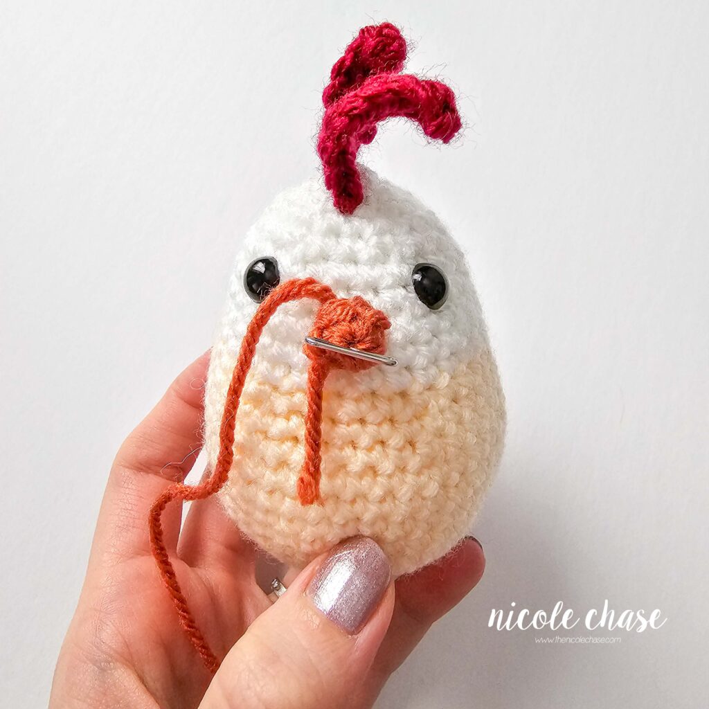 beak pinned to the front of the crochet chicken
