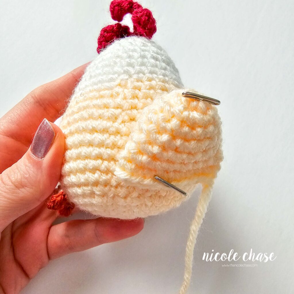 tail pinned to the back of the crochet chicken