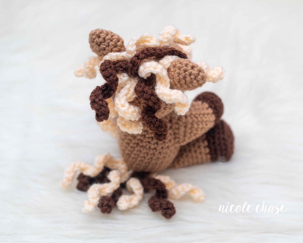 close up of the crochet horse mane and tail curls in brown and cream colors