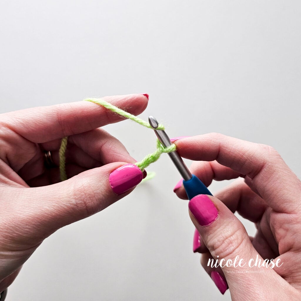 The hook is yarning over again, with already 3 finished chains, working on the 4th.