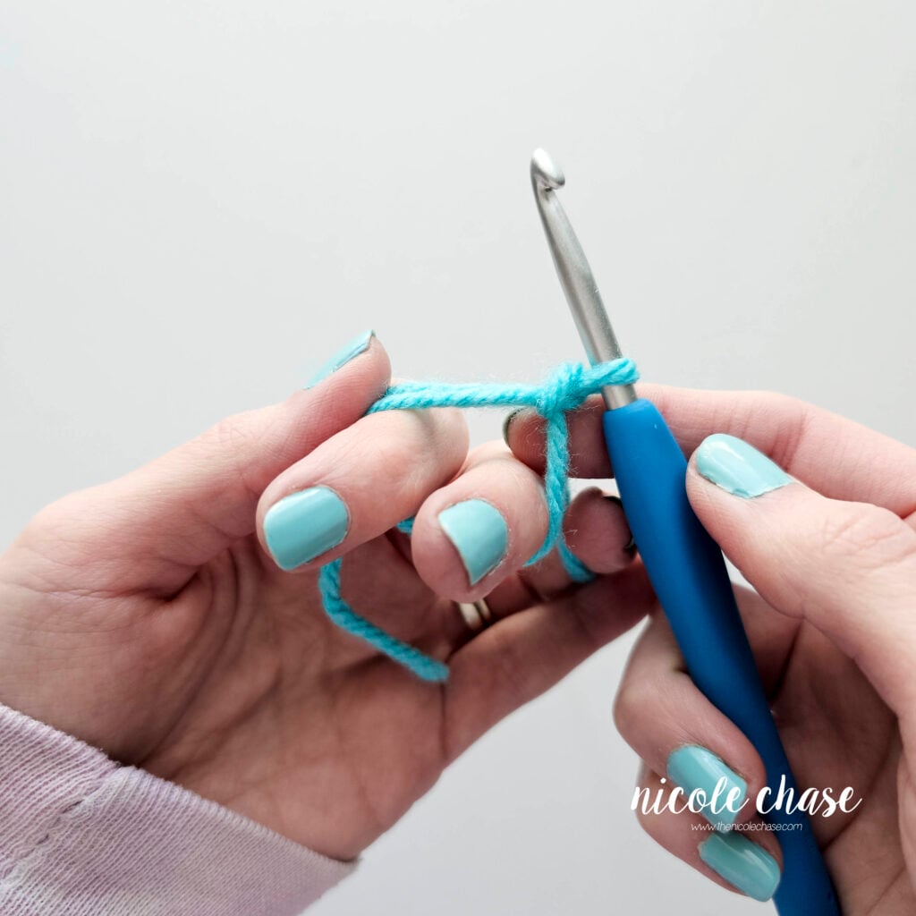 Carefully removing the pointer and middle fingers from the magic ring loop.