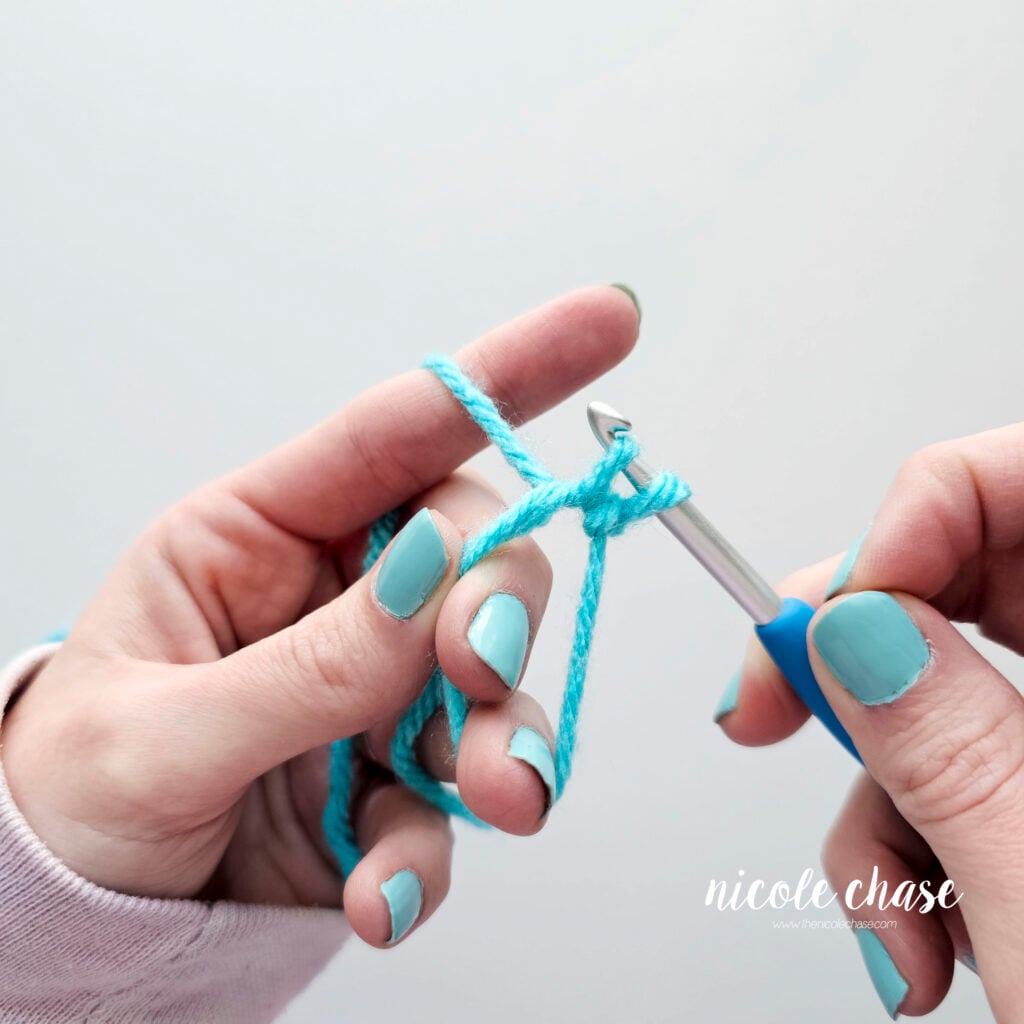 There are now two loops on the crochet hook, in the process of creating a single crochet stitch.