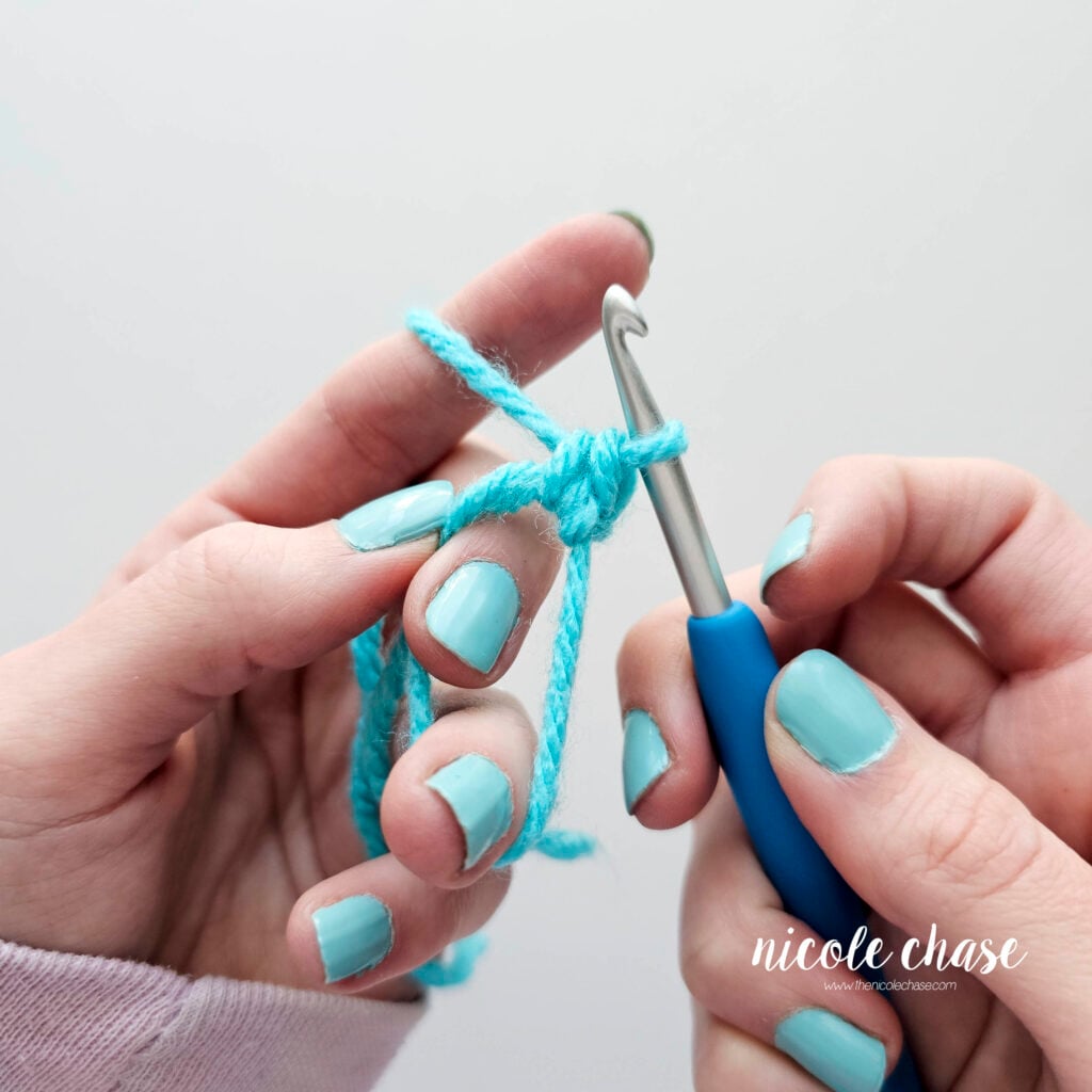 The working yarn has been pulled through both loops on the hook, creating a single crochet stitch.