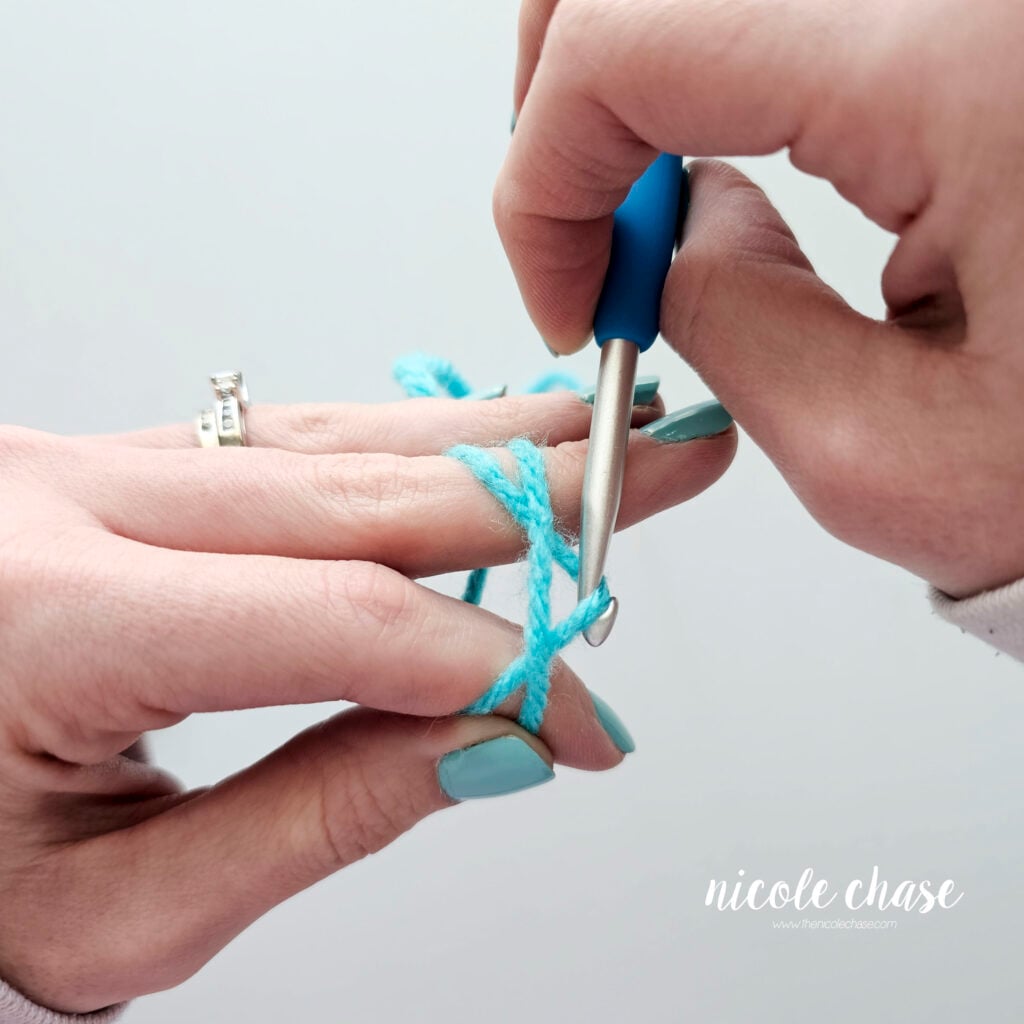 The crochet hook has pulled the back strand of yarn beyond the front strand of yarn.