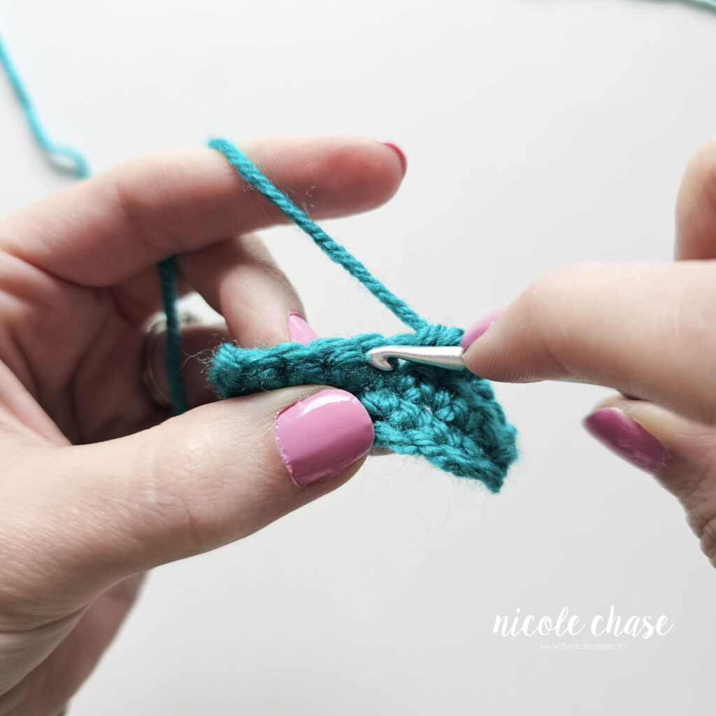 A close-up of a swatch of single crochet stitches demonstrating where to insert your hook when working a single crochet into the top loops of another single crochet.