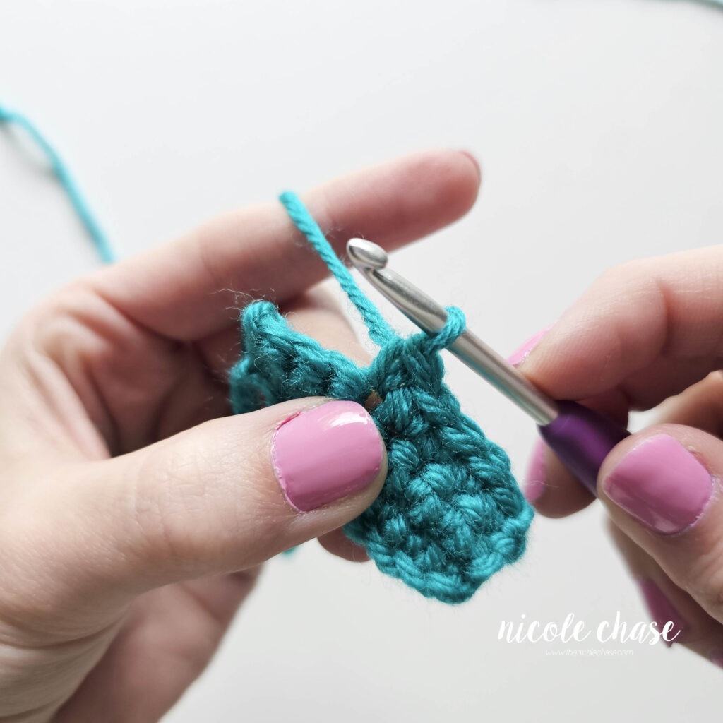 The single crochet stitch has been completed with the final yarn over being pulled through to finalize the stitch.