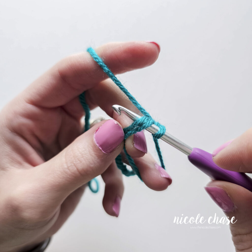 Inserting the hook into the center of the magic ring.