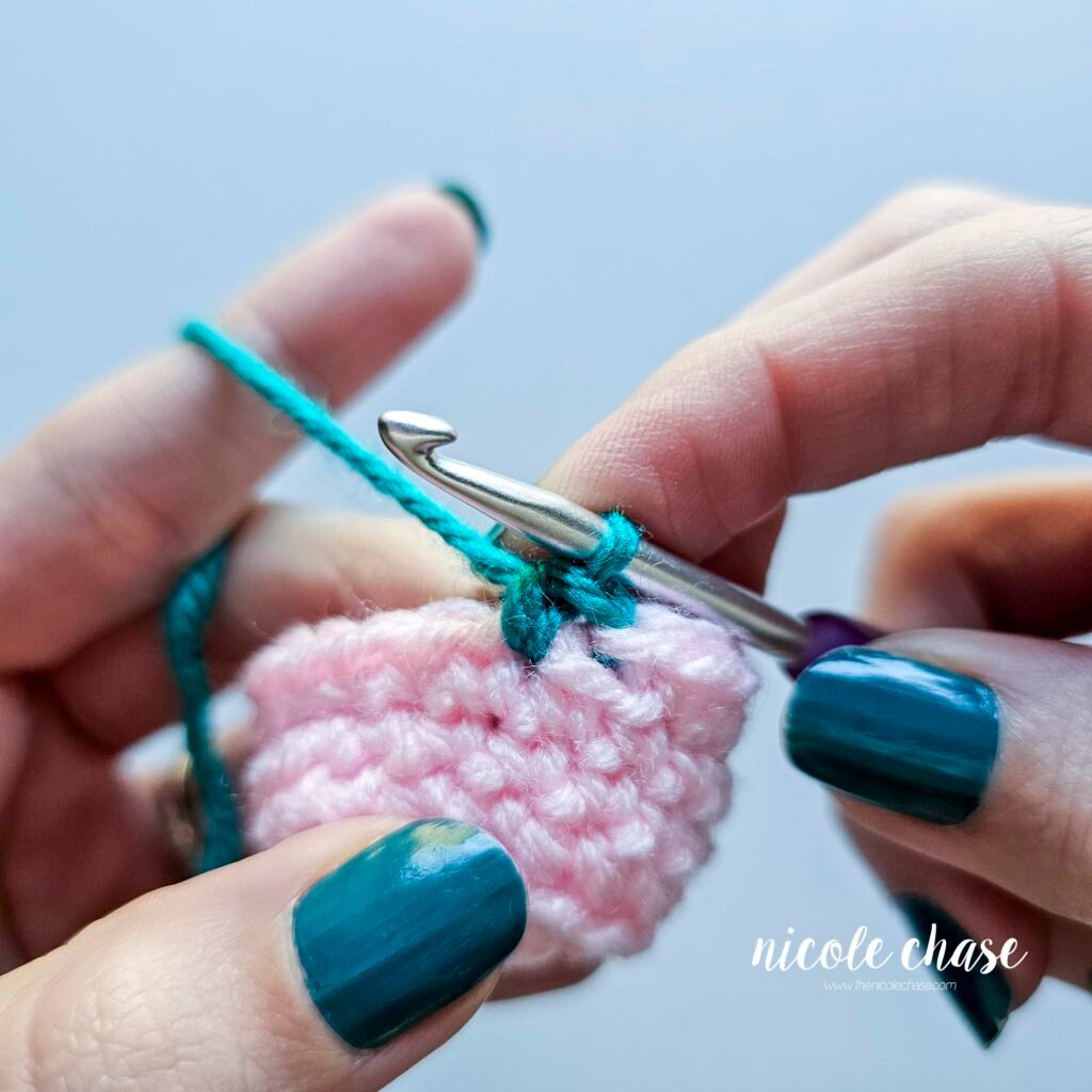 The first single crochet stitch in the new color, into the next stitch, after the invisible color change setup for amigurumi.