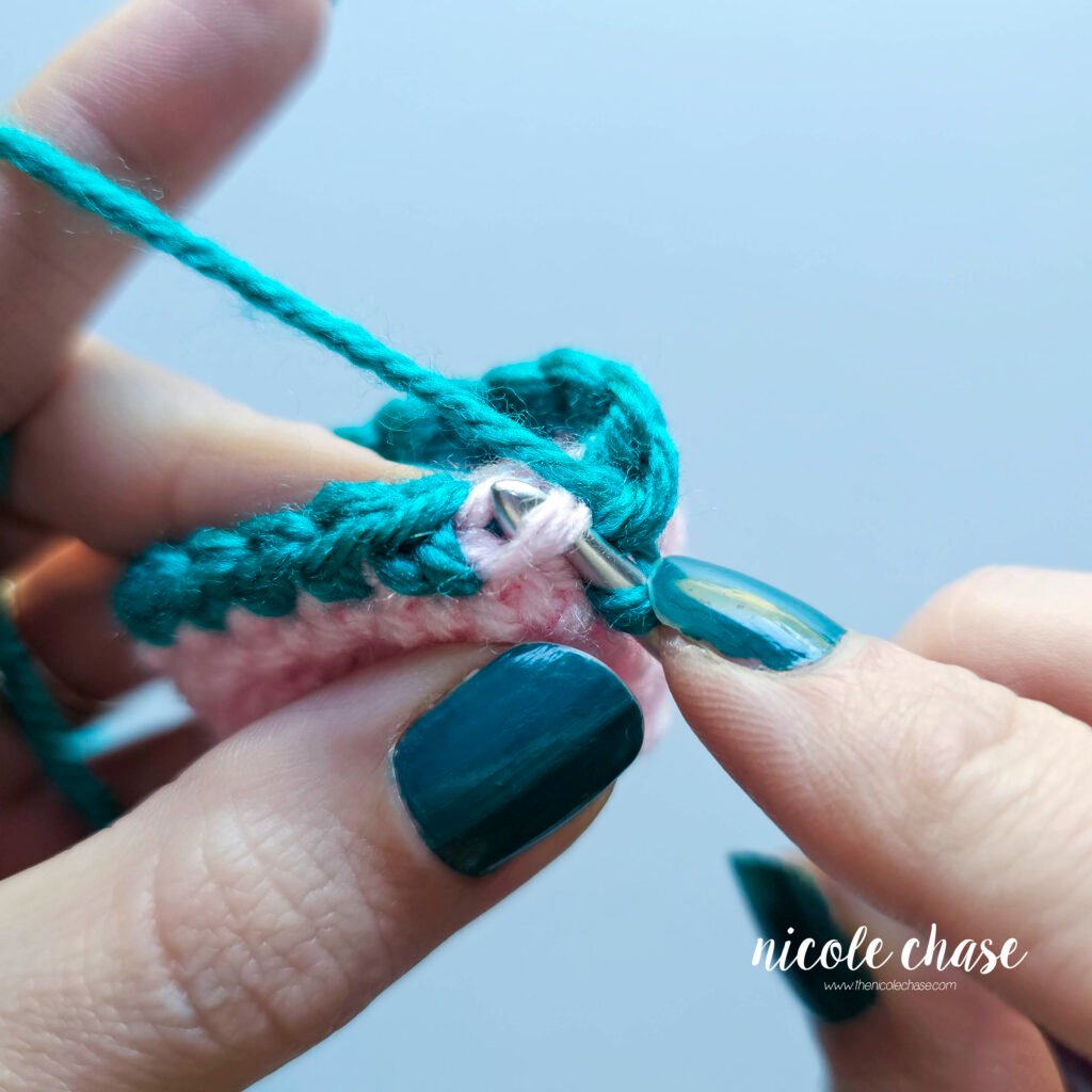 Showing the hook inserted into the unworked front loop for the seamless color change in crochet amigurumi, part 2.