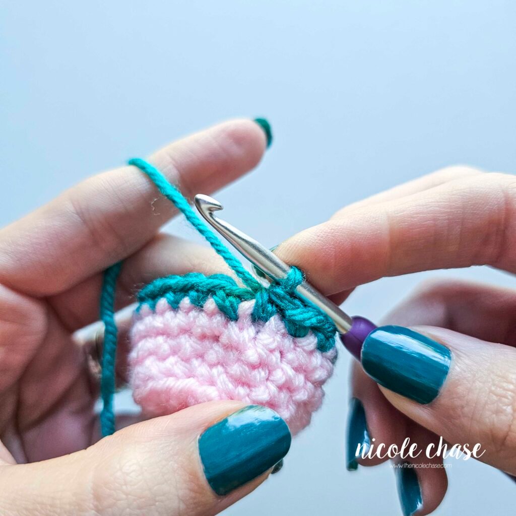 Final single crochet stitch worked through the unworked front loop and loops from the color change, completing the invisible color change method.