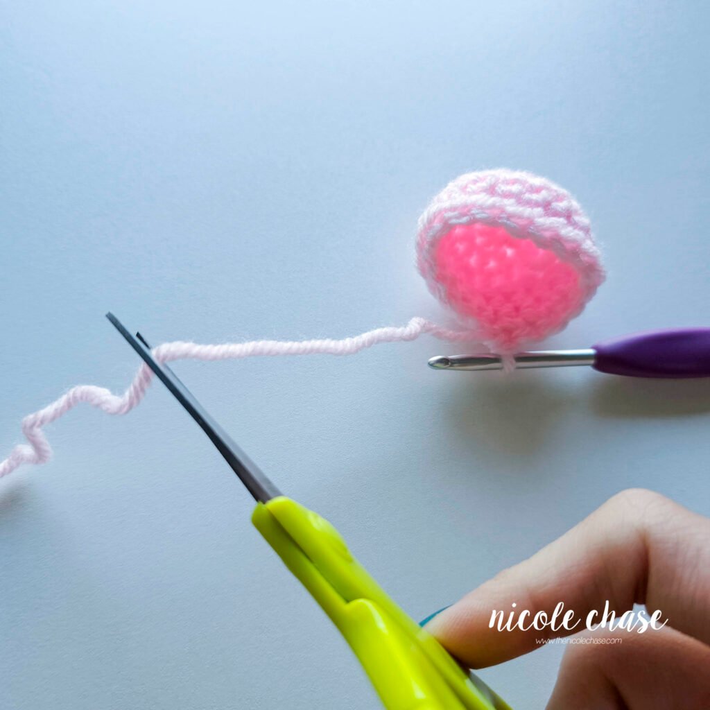 Cutting the first color of the amigurumi piece before starting the seamless crochet color change.