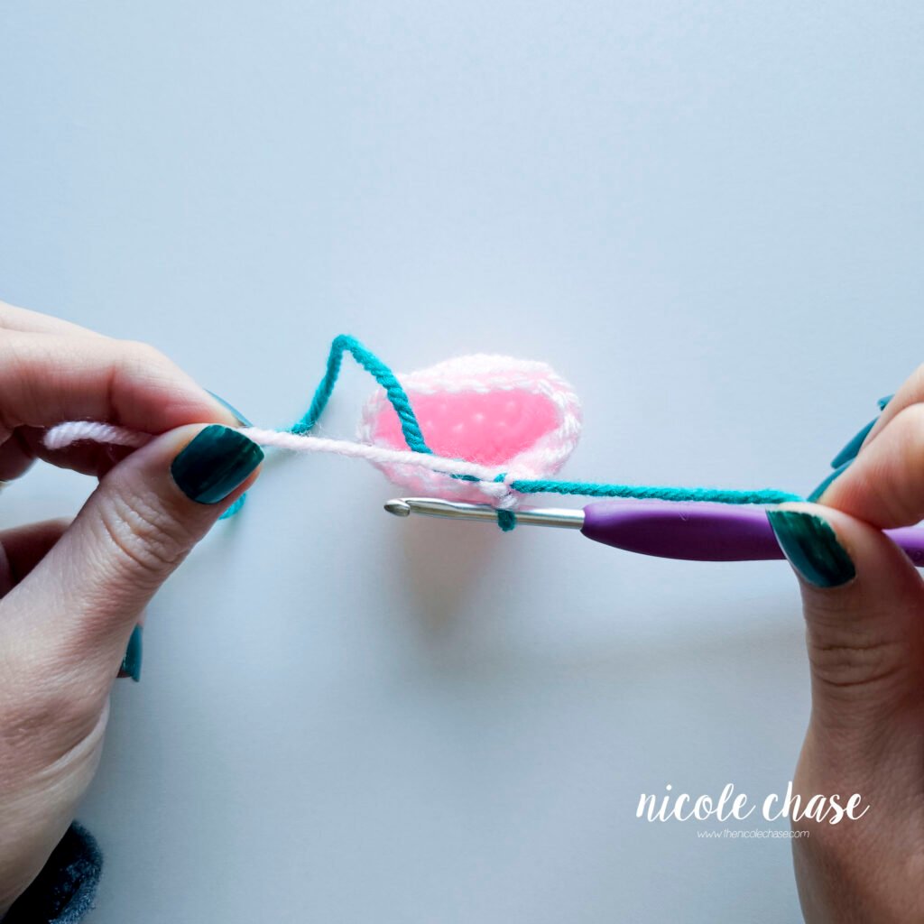 Tying a secure know with the new and old yarn tails insider the amigurumi piece for a hidden, invisible color change.