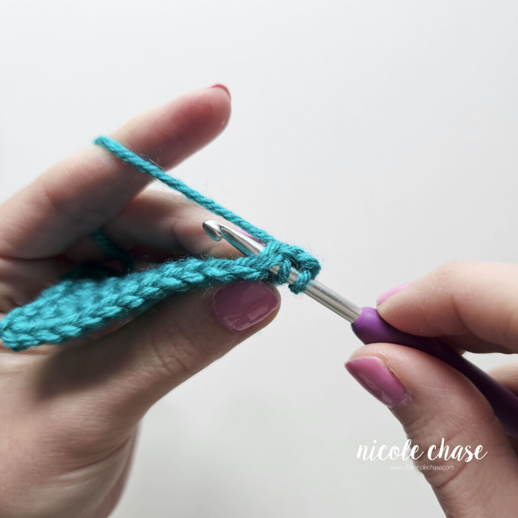 Step-by-step tutorial photo showing the crochet hook being inserted into the second stitch during a single crochet decrease.