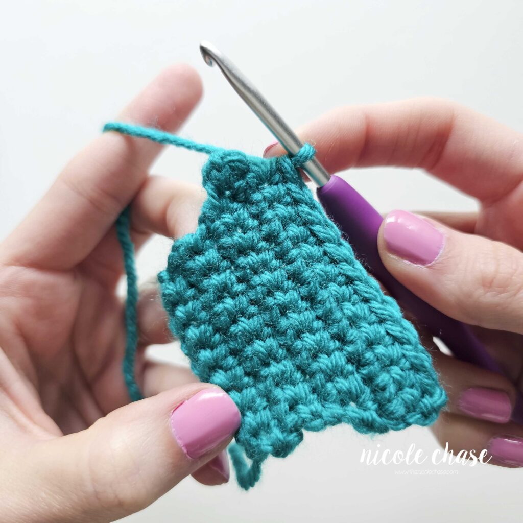 Progress photo showing single crochet stitches worked across a middle row before completing the edge shaping with a decrease.