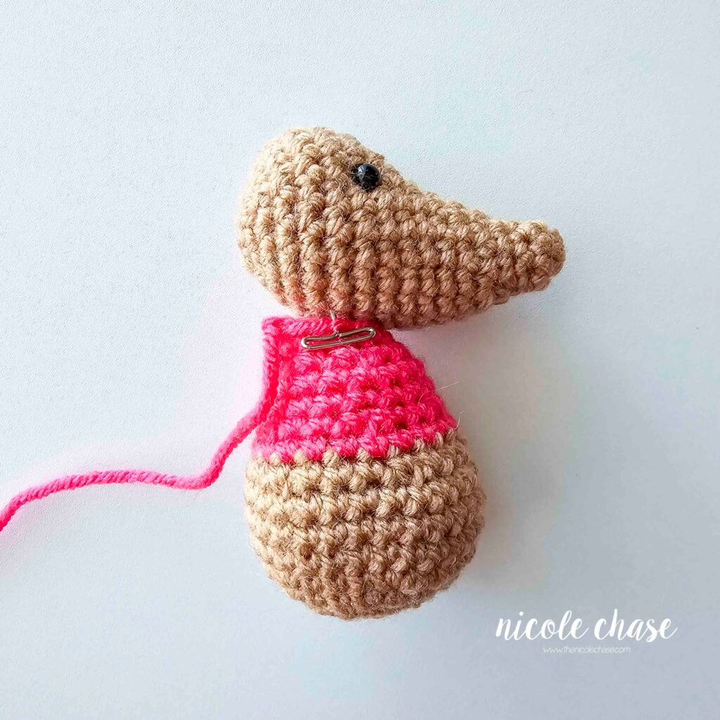 Pinning the crochet body of the mouse amigurumi to the bottom of the head, prior to sewing. 