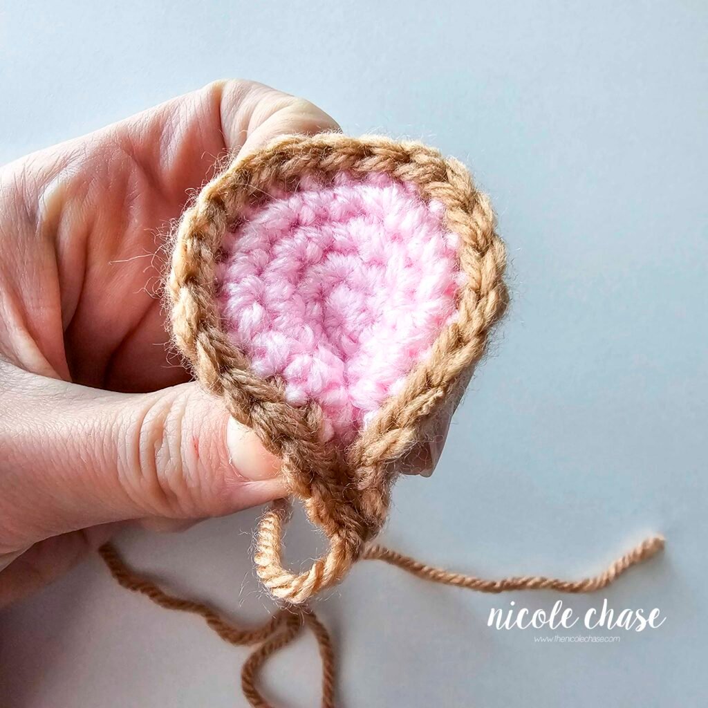 Shaping the mouse's crochet ear to create a pinched look, part 2.