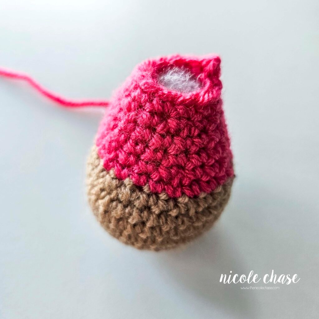 Finished body piece made with brown yarn and pink yarn for the sweatshirt. The piece is filled with poly-fil stuffing. 