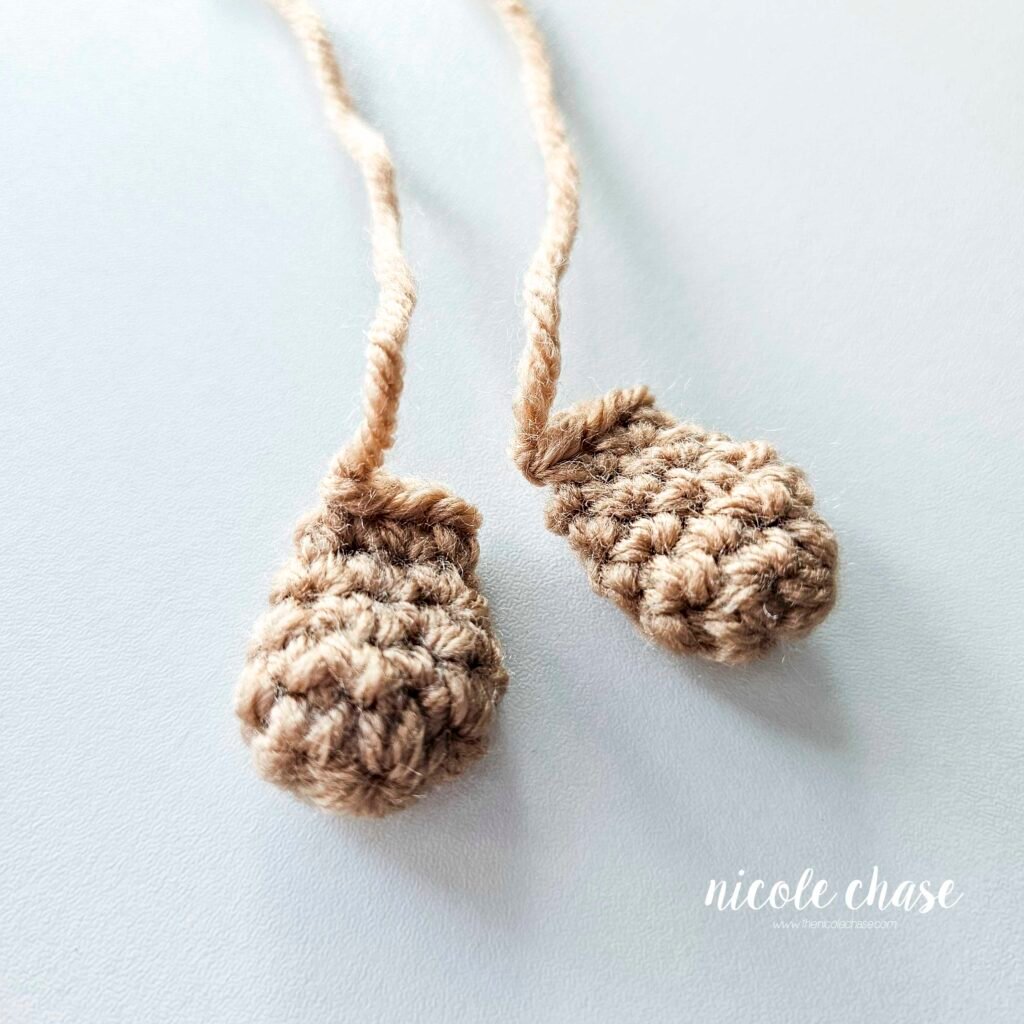 The finished feet for the crochet mouse shown in brown yarn. 