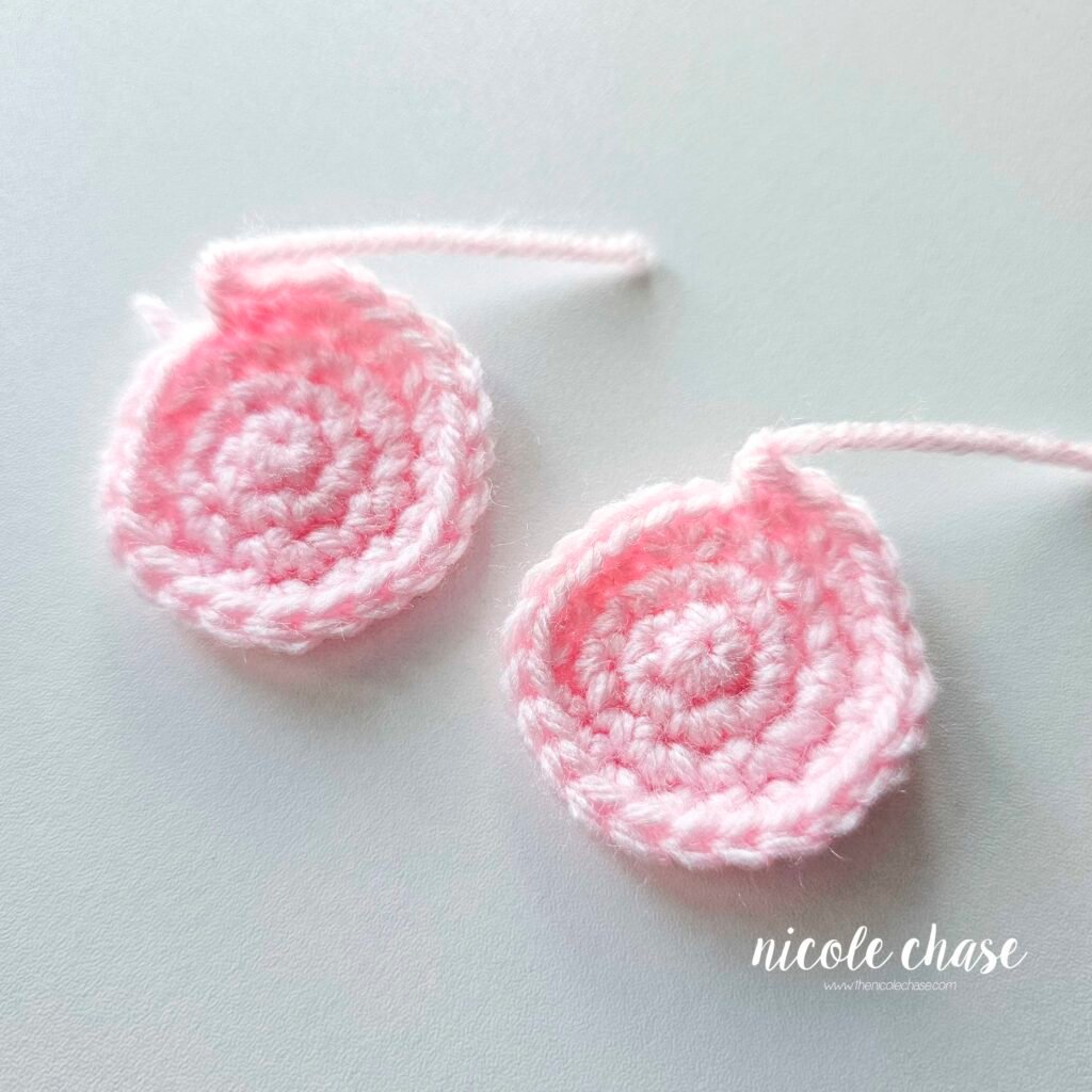 The finished inner ear pieces in a light pink yarn. 