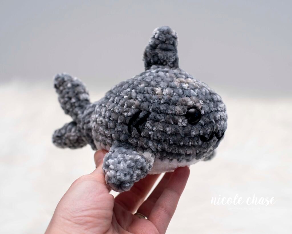 Sheldon the Shark chunky yarn amigurumi pattern finished project, showing a small gray and white plush shark crochet pattern held in a hand.