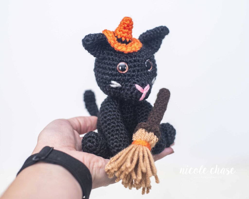 halloween black cat crochet pattern sitting in a hand