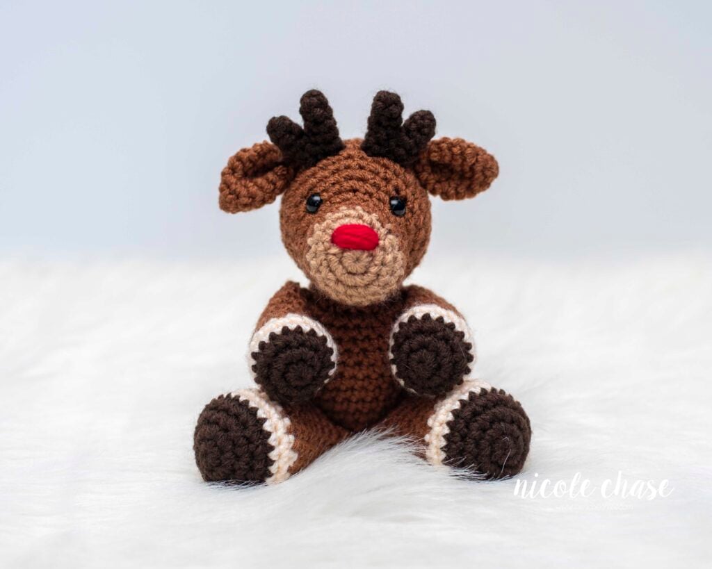 Finished Randall the Amigurumi Deer with a red nose, demonstrating the Rudolph alteration option for the free reindeer crochet pattern.
