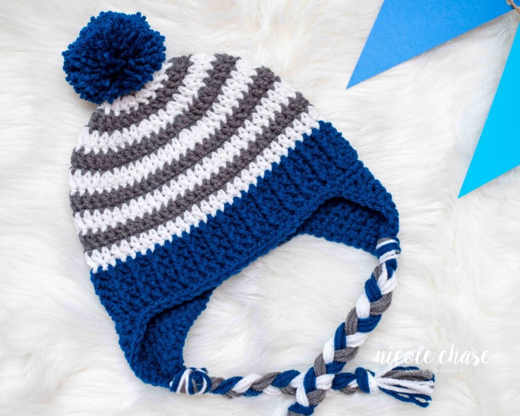Finished Spirit Earflap Hat made with this free earflap hat crochet pattern, made with gray and white stripes and navy blue accents.