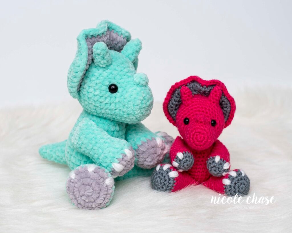 Mini Tanner the Triceratops crochet pattern made with plush yarn (left) and worsted weight yarn (right) for size comparison. 