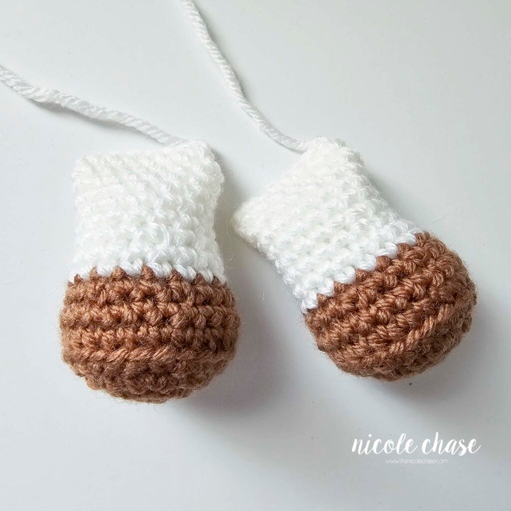 The finished crocheted legs of the crochet cow pattern with brown hooves and white legs.