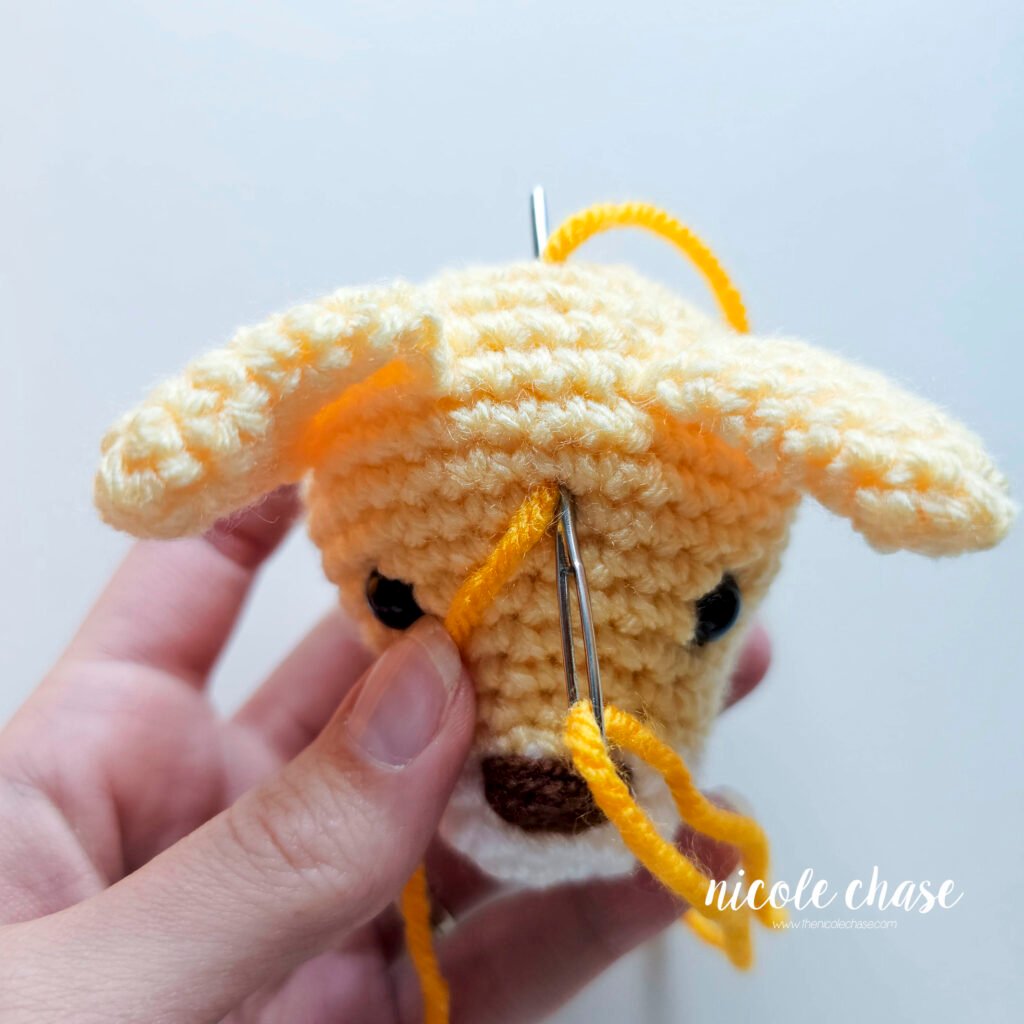 Embroidering the first stripe on the cat crochet pattern, step 2. 