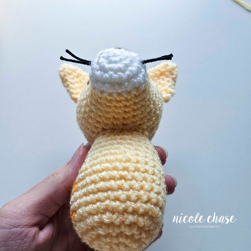 Underside view of the cat's head sewn in place. 