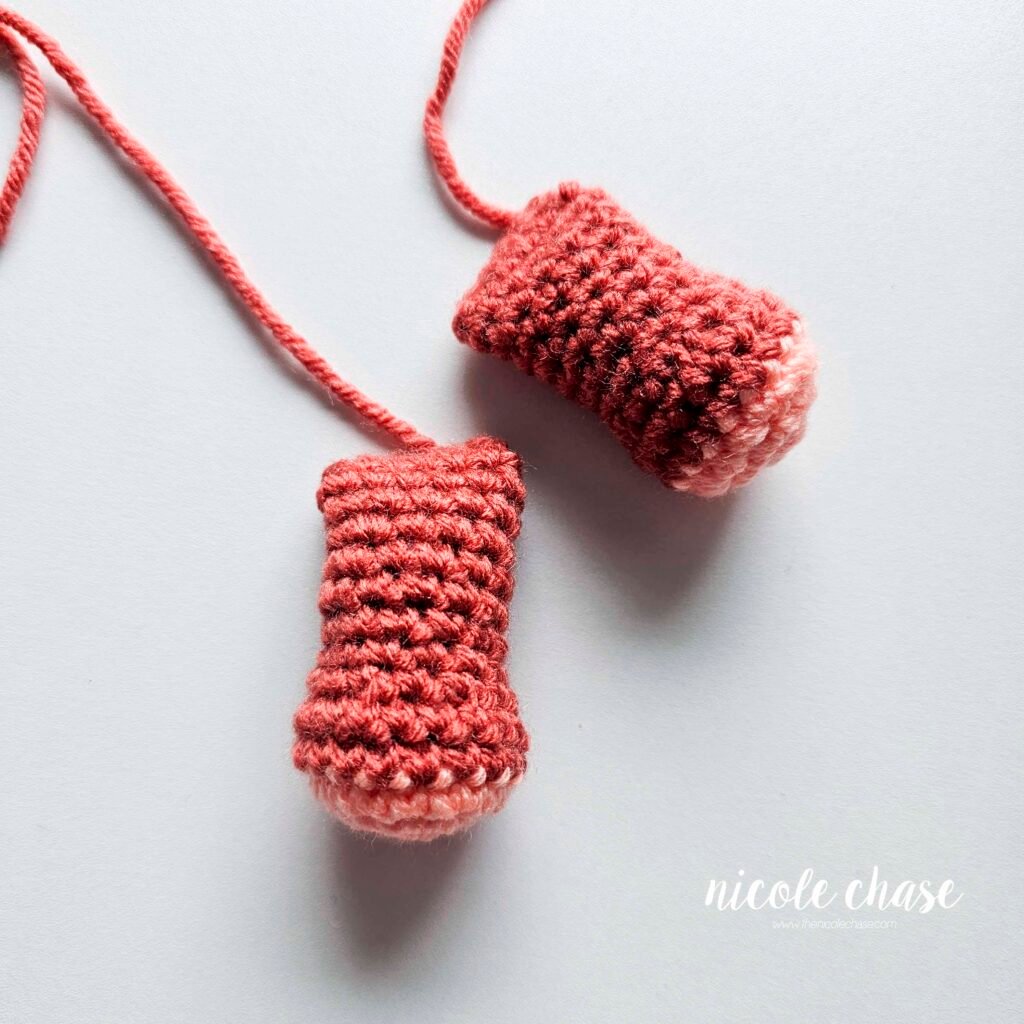 Finished arm pieces of the free small dinosaur crochet pattern for Mini Archie the Ankylosaurus.