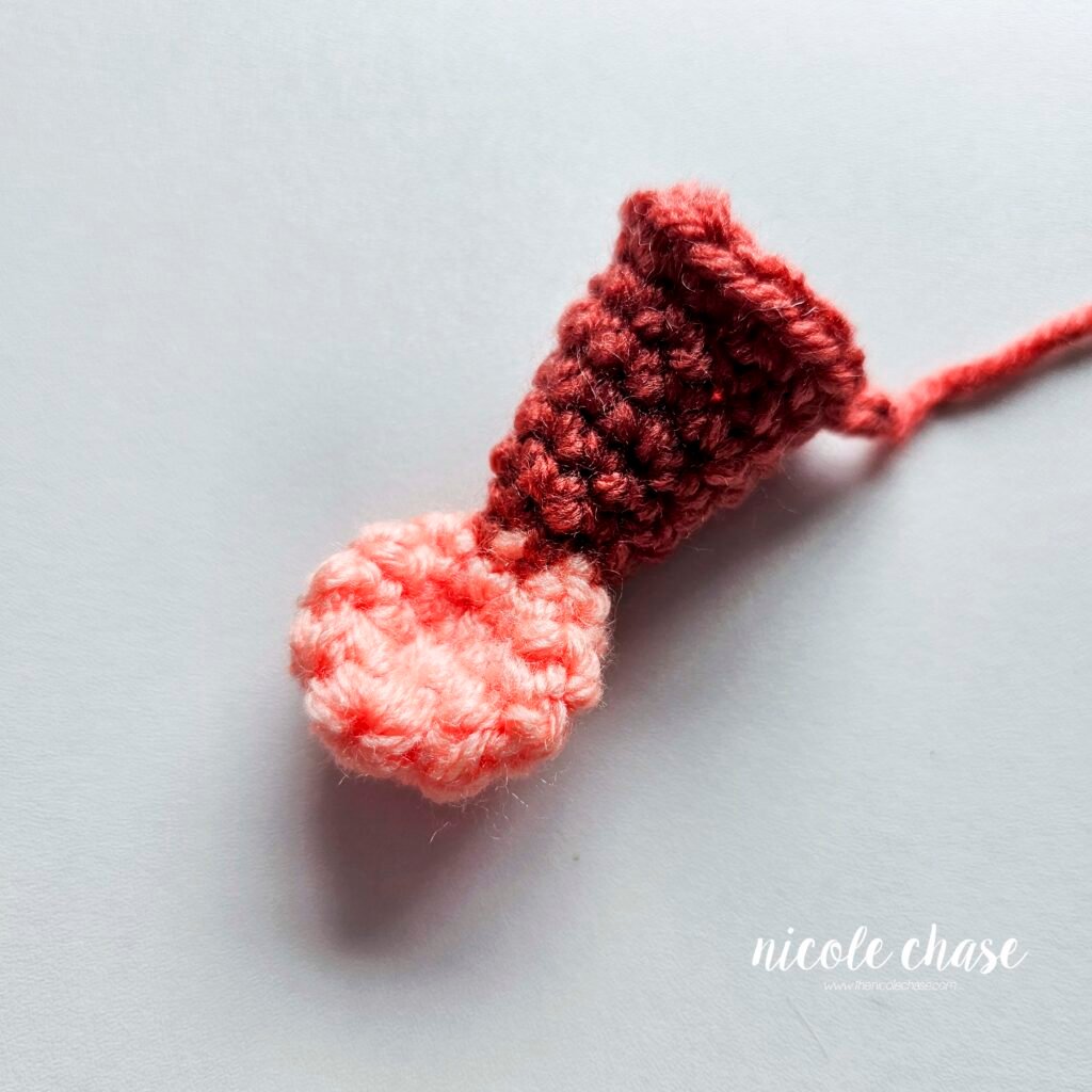 Finished tail piece of the free small dinosaur crochet pattern for Mini Archie the Ankylosaurus.