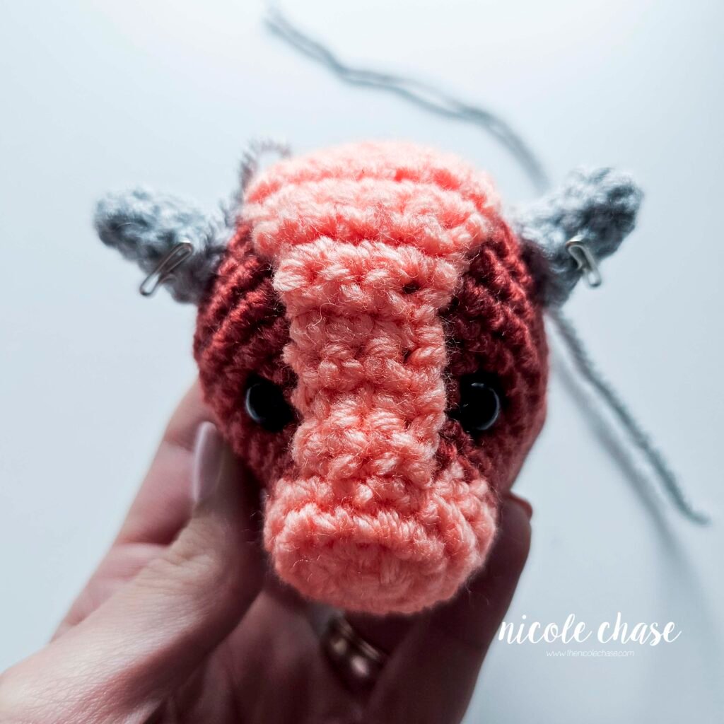 Large spikes of the free small dinosaur crochet pattern held into place with pins.