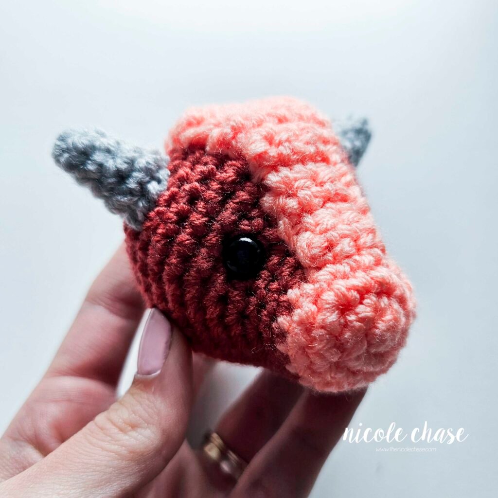 Large spikes of the small dinosaur crochet patterns free sewn into place on the head of Mini Archie, view 1.