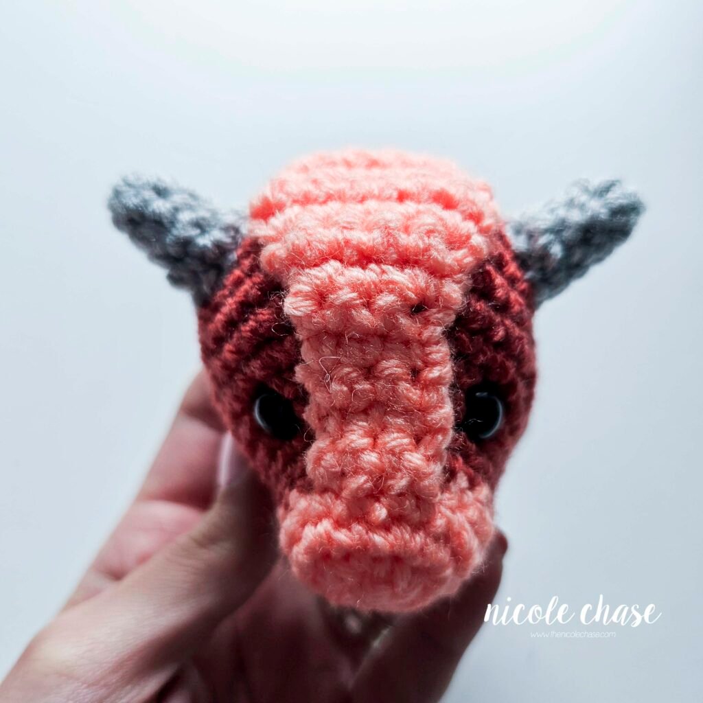 Large spikes of the small dinosaur crochet patterns free sewn into place on the head of Mini Archie, view 2.