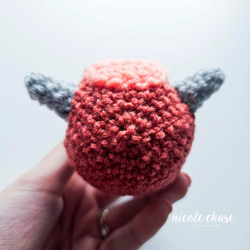 Large spikes of the small dinosaur crochet patterns free sewn into place on the head of Mini Archie, view 3.