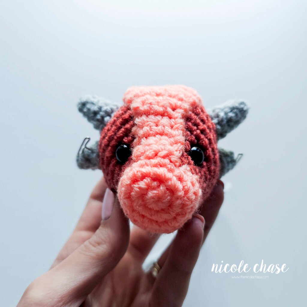 Small spikes of the free small dinosaur crochet pattern held into place with pins.