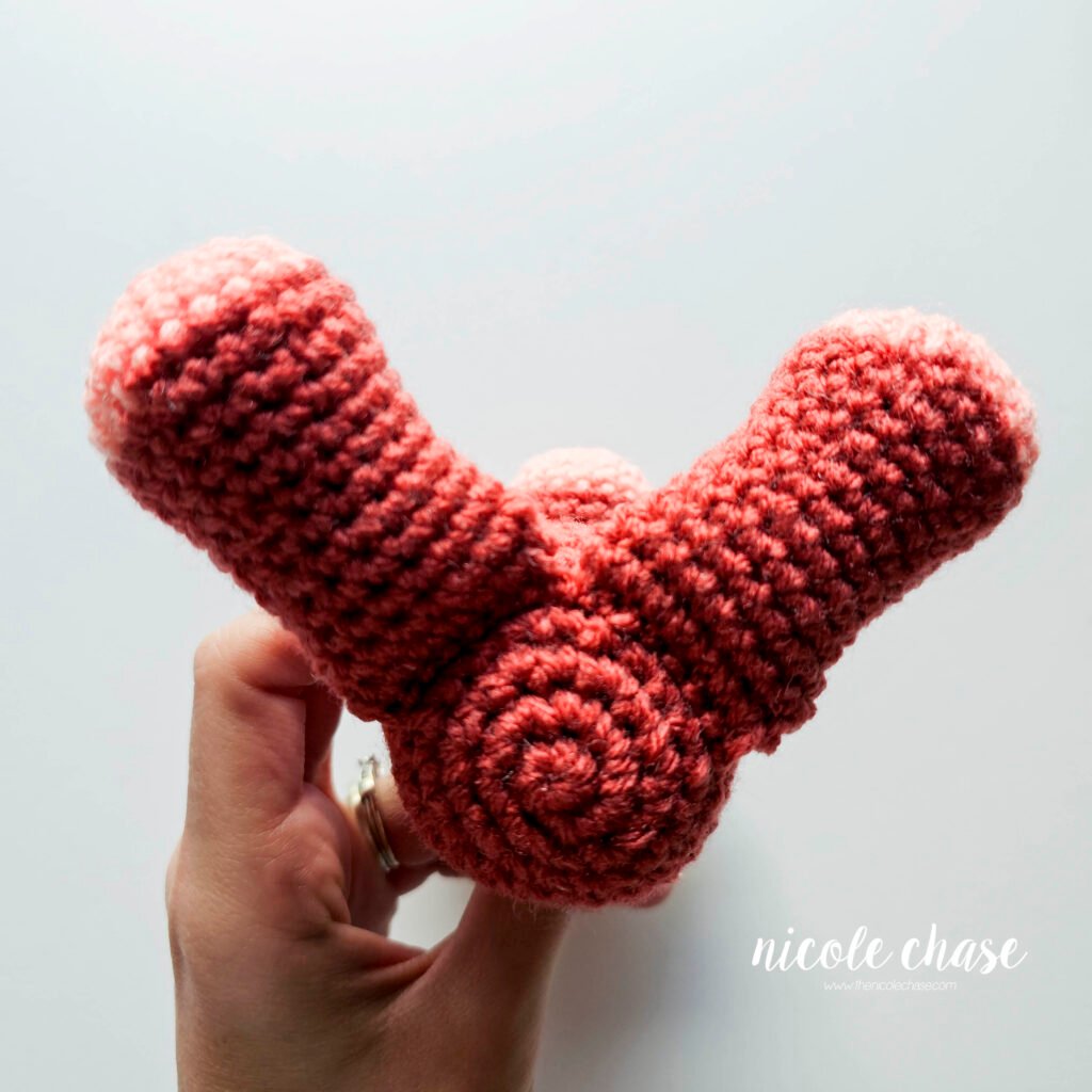 Mini dinosaur crochet pattern free with the legs sewn into place, view 3.