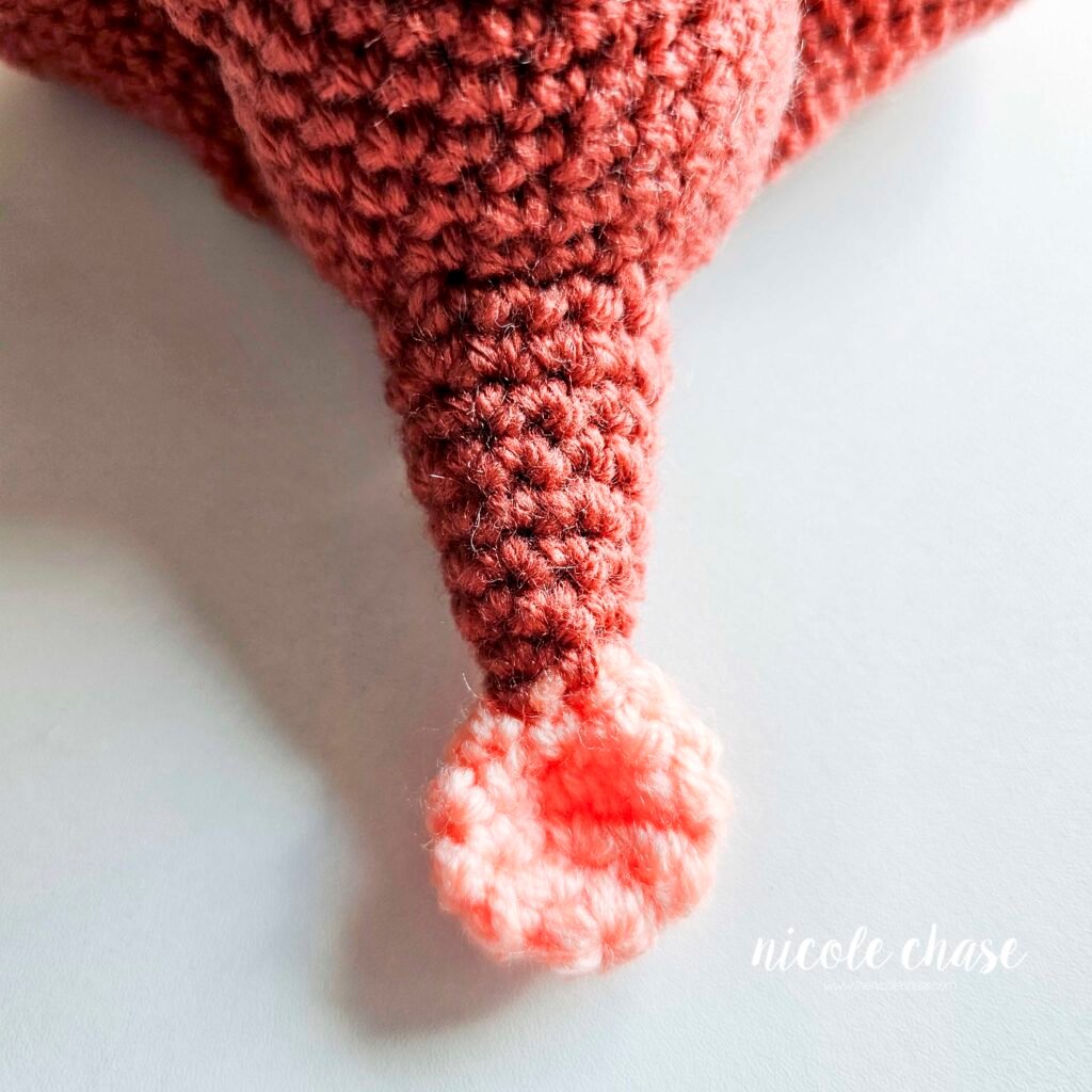 Tail of the crochet ankylosaurus sewn into place, view 1.