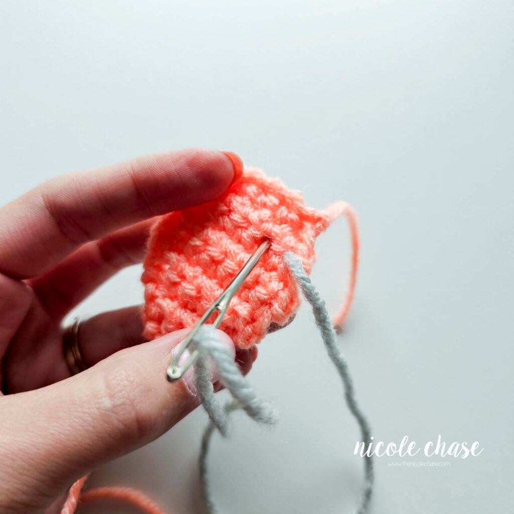 Embroidering the bumps on the back plate of the crochet ankylosaurus, step 2.